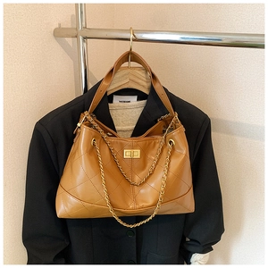 Close-up of caramel quilted leather bag featuring a vintage gold turn-lock and chain strap
