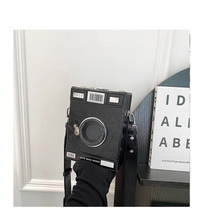 Detail of creative vintage camera crossbody bag with textured black PU leather and text