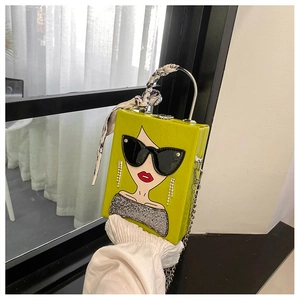 Detail of green hardshell box bag with silk scarf handle and cartoon female portrait