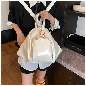 Close-up of a white glossy heart-shaped backpack with a cute astronaut rabbit charm