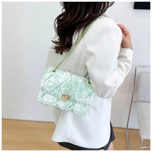 Détail du sac matelassé vert menthe avec bords effilochés et fermoir tournant doré