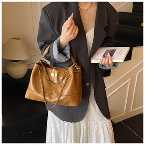 Detail of vintage brown quilted leather bag with gold chain strap and twist lock