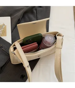 Detail view showing interior capacity of plaid underarm bag with zipper pocket