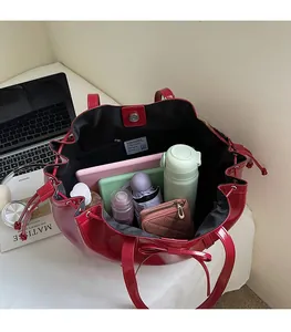 Vue intérieure du grand sac fourre-tout rouge brillant montrant sa capacité pour tablette et objets