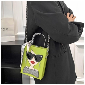 Neon green box bag with cartoon face motif and silk scarf handle worn by a model
