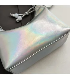 Détail d'un sac argenté holographique avec texture craquelée et cordon de serrage perlé