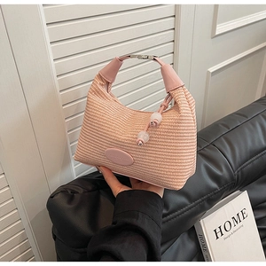 Detail of pink woven handbag with leather handle and decorative white beads