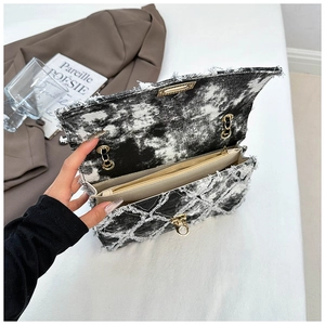 Détail du sac bandoulière en denim tie-dye avec fermoir doré et poche zippée interne