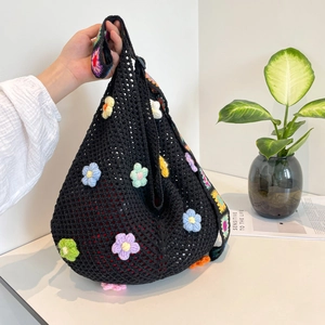 Handgefertigte schwarze Häkeltasche mit bunten 3D-Blumen und Regenbogenriemen
