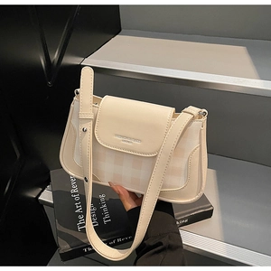 Close-up of beige checkered shoulder bag with smooth leather flap on geometric steps