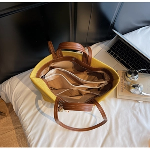 Detailed interior of yellow canvas tote showing multiple compartments and zipper pockets