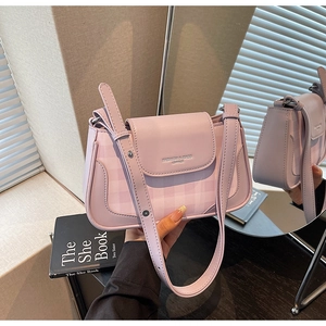 Close-up of pink plaid crossbody bag with leather trim and embossed brand lettering