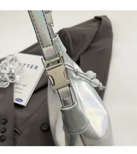 Détail du sac à main argent holographique avec boucle métallique et texture craquelée