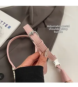 Detail of adjustable pink leather strap with silver buckle and litchi texture on handbag