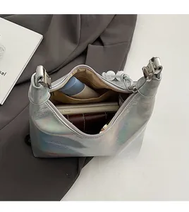 Vue de dessus du sac hobo laser argenté montrant l'intérieur spacieux avec téléphone