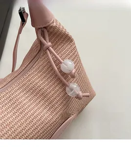 Detailed macro view of pink woven shoulder bag with leather drawstring and clear beads