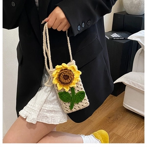 Détail du sac bandoulière tissé main avec motif tournesol et bandoulière en maille douce