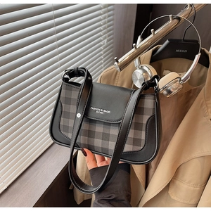 Detail view of plaid underarm bag with leather trim and stylish shoulder strap