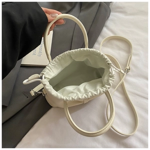 Top view of cream drawstring bucket bag with spacious interior and adjustable strap