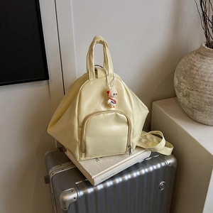 Minimalist cream yellow PU leather backpack on a silver suitcase with a cute lamb pendant