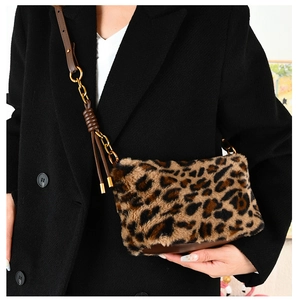 Detail of leopard print plush bag with leather knot strap and gold metal chain link