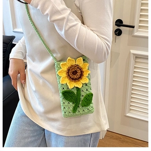 Vue détaillée d'un mini sac vert crocheté à la main avec motif de tournesol jaune