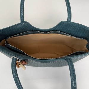 Vue de dessus du sac cabas tressé vert paon avec doublure marron et fermeture éclair
