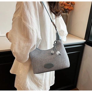 Detail of woven texture and blue leather logo patch on a chic shoulder bag for women