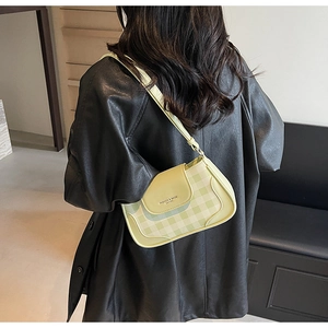 Close-up of light green checkered underarm bag with flap and metal fashion logo