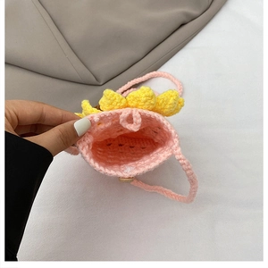 Gros plan du sac tournesol au crochet rose montrant la texture tricotée et le bouton