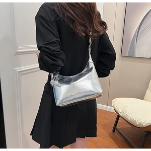 Détail du sac demi-lune argenté métallisé avec breloque sphérique et texture plissée