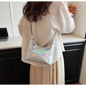Détail du sac hobo argenté holographique avec un pendentif sphérique blanc sur la bandoulière
