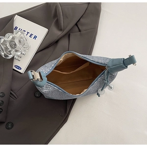 Detail view of the interior blue woven handbag showing a zipper pocket and metal buckle