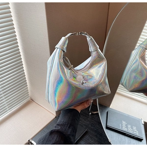 Détail du sac à main holographique argenté avec pompon de perles et texture métallique
