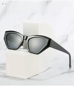 Macro detail of geometric cat eye sunglasses with thick black frames on marble