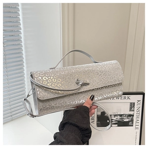 Dettaglio borsa a tracolla argento leopardata con chiusura a nodo metallico e trama lucida
