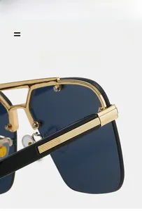 Detail view of large frame sunglasses with gold-black metal double bridge and blue lenses