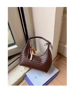Détail du sac Hobo tressé marron foncé avec boucles argentées et pendentif de perles
