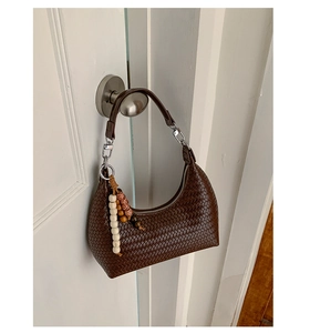 Détail du sac croissant tressé marron foncé avec breloque en perles colorées