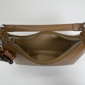 Vue de dessus d'un sac cabas tressé marron ouvert avec fermeture éclair et perles