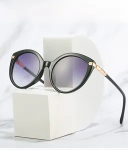Detail of cat-eye sunglasses with gradient lenses and gold metal temple accents