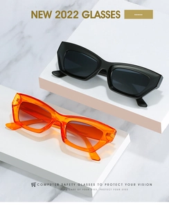 Détail de lunettes de soleil œil-de-chat vintage noires et orange sur marches en pierre
