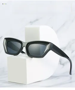 Gros plan de lunettes de soleil œil de chat noires sur des supports géométriques blancs