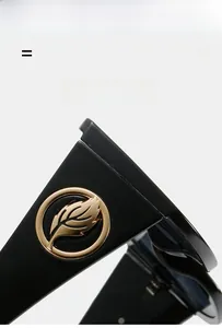 Détail de la branche de lunettes noire avec logo décoratif en feuille dorée