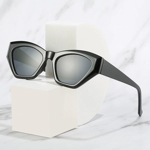 Modern black cat-eye sunglasses with geometric frames on a marble background