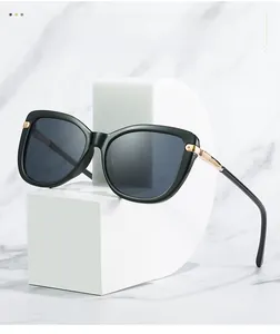 Detailed close-up of black sunglasses featuring golden metal accents on the temples