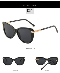 Detail view of stylish black cat eye sunglasses featuring gold metal hinge accents
