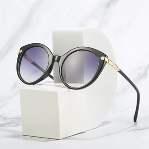 Fashionable round sunglasses for women with black cat-eye frames and purple gradient lenses