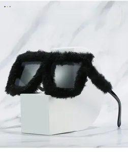 Detail view of black faux fur trimmed square cat-eye sunglasses on a white stone base