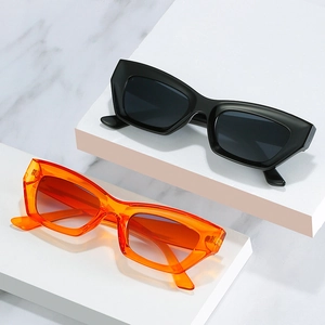 Lunettes de soleil œil-de-chat rétro noir mat et orange sur support en marbre
